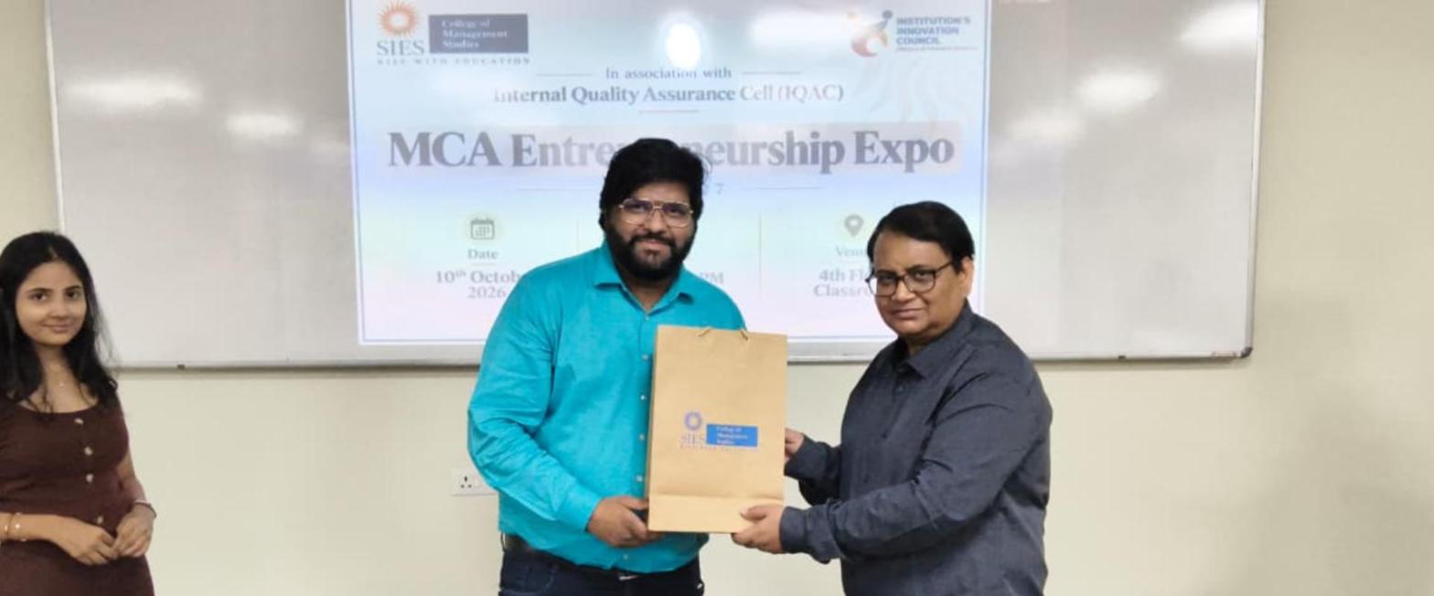 Prof. Pankaj Srivastava felicitating Sarthak Dayama, co-founder of Umora Fashion, with Sapna Pandey, at the SIES MCA Entrepreneurship Expo
